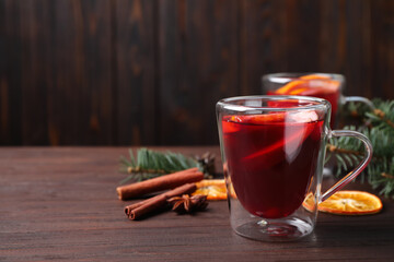 Delicious mulled wine on wooden table, space for text