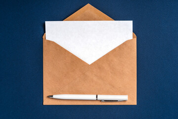 An envelope with a white sheet of paper on a dark blue background and a white pen. Concise,...