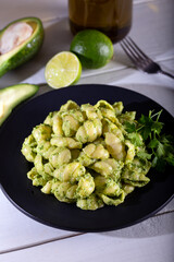 Pasta with pesto sauce on wooden background.