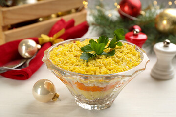 Traditional russian salad Mimosa served on white table