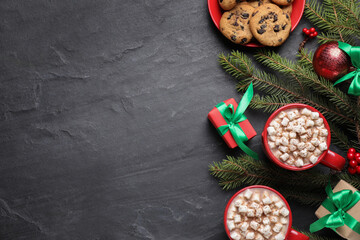 Flat lay composition with delicious hot cocoa on black table, space for text