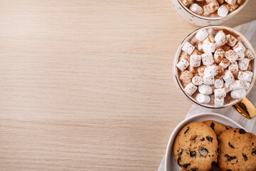Hot drink with marshmallows and cookies on wooden table, flat lay. Space for text