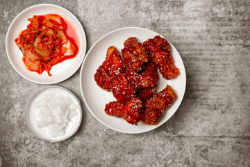 Top view Korean spicy fried chicken with side dishes.