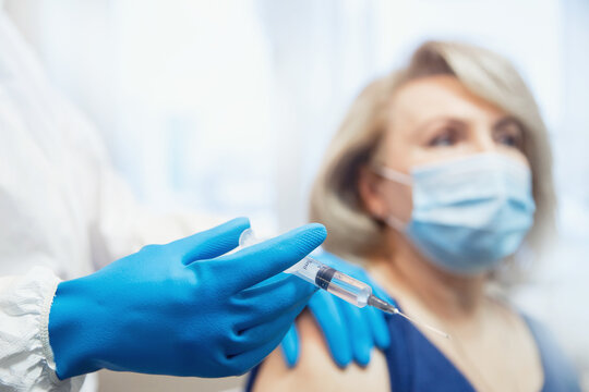 Concept vaccination Covid-19 or coronavirus of senior people in houses, doctor visits home. Nurse giving injection vaccine to elderly woman clinic - Powered by Adobe