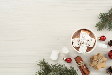 Fototapeta na wymiar Flat lay composition with delicious marshmallow cocoa and Christmas decor on white wooden table. Space for text