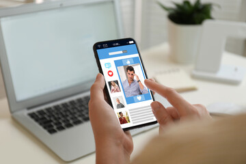 Young woman visiting online dating site via smartphone indoors, closeup