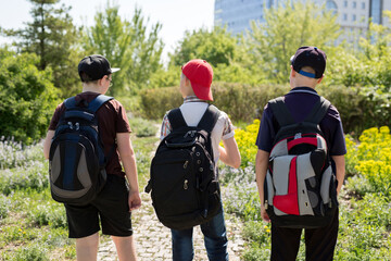 Backs of schoolkids with colorful rucksacks