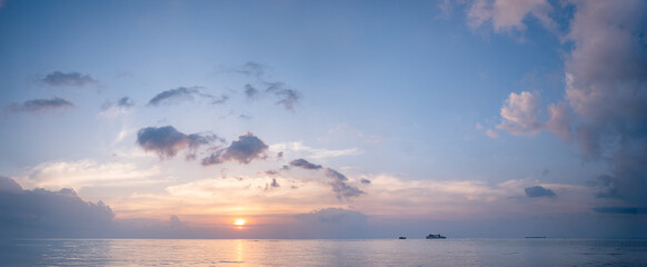 Fototapeta na wymiar Beautiful panoramic tropical purple blue sea sunset and yellow clouds background