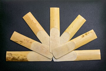 Saxophone reeds laid out on a black background