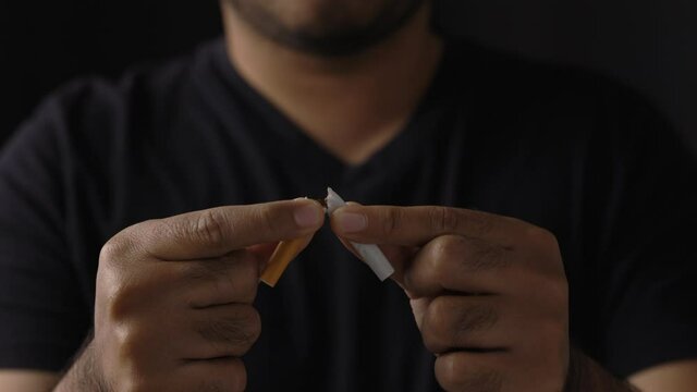 World No Tobacco Day. The young man quit smoking for his good health. He broke a cigarette in two.
