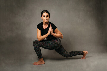 Fototapeta na wymiar Young attractive girl doing yoga, side angle pose. Relaxation and meditation concept. Studio photo shoot.