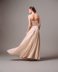 Elegant backless moscato dress. Beautiful pink chiffon evening gown. Studio portrait of young...