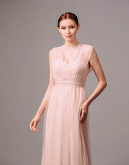 Elegant moscato dress with bow. Beautiful pink chiffon evening gown. Studio portrait of young...