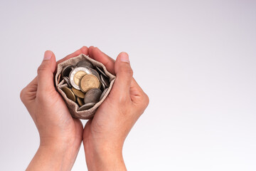 Fototapeta premium Woman's hand and money in a sack separate from white background, money-saving idea for the future and doing business in the Covid-19 era.