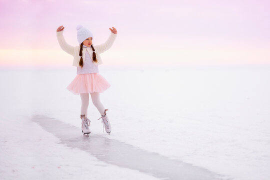 Little girl skating on ice in morning light at dawn. Winter sports on natural background. - Powered by Adobe