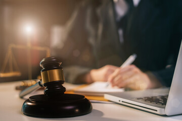 Justice and law concept.Male judge in a courtroom the gavel, working with digital tablet computer on wood table. 