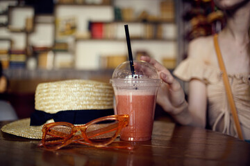 woman sitting at a table in a restaurant glass fresh hat glasses rest