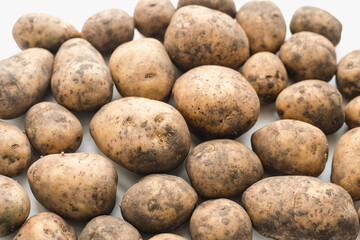 potatoes on white background, dirty potatoes, a bunch of potatoes