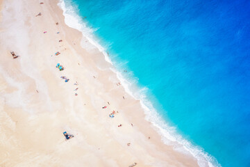 Aerial view of people enjoying the blue sea of the famous Myrtos beach on the Ionian island of Cephalonia, Greece
