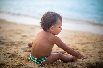 cute toddler kid playing in the sand by the sea