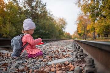 gender differences in children. cute little girl plays on the railway tracks