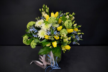 A bouquet of bright, juicy flowers on a dark background. Spiral assembly technique without decorative packaging.