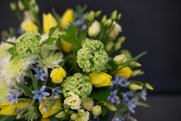 A bouquet of bright, juicy flowers on a dark background. Spiral assembly technique without decorative packaging.