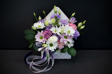 Composition of fresh flowers in an envelope. Floral letter.