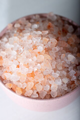 Fototapeta na wymiar Pink rock salt in a pink bowl on a white background. Himalayan salt in bowl. 