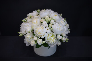 White peonies collected in a composition. Fresh, natural flowers, on a dark background