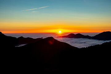 Sunrise with sea of clouds in horizon	