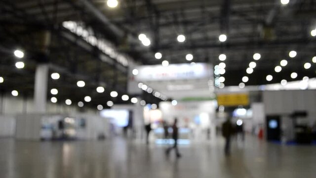 Blurred background. Inside big empty building with high ceiling.