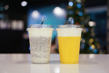 Iced smoothie with cheese drink. Two cup of mango smoothie and cookie and cream smoothie, topped with cheese cream on a white table at cafe.