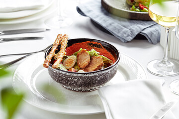 Caesar salad with bread sticks, quail eggs, cherry tomatoes and grilled chicken in plate on white background