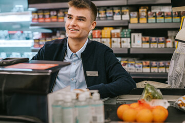 Man working at a supermarket checkout counter