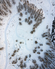 drone aerial top down view of closed road in winter due to snow, used as trekking trail. alps, italy