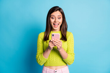 Photo of young beautiful girl amazed excited surprised news use cellphone chat communicate isolated...
