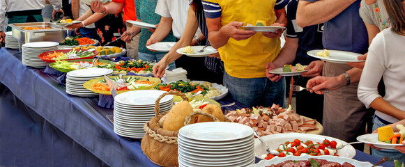 People serving themselves at a buffet, food concept 
