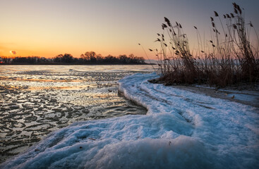 Winter landscape with sunset sky and frozen river. Daybreak