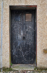 Old Black Wooden Door Protected by Barbed Wire 