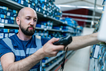 young bold man scanning parcels in a warehouse