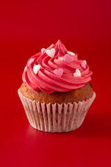 Cupcakes decorated with sugar hearts for Valentine's Day on red background