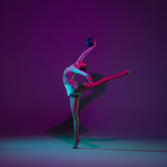 Free. Young female athlete, rhythmic gymnastics artist dancing, training with ball isolated on...