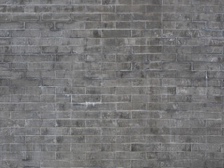 A gray brick wall with dark and light spots of dirt and smudges. Not seamless texture