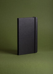 Black sketch and notepad on green background