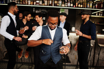 Stylish african american man against group of handsome retro well-dressed guys gangsters spend time at club, drinking on bar counter. Multiethnic male bachelor mafia party in restaurant. - obrazy, fototapety, plakaty