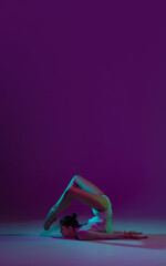Flyer. Young female athlete, rhythmic gymnastics artist dancing, training with tape isolated on purple studio background in neon light. Beautiful girl practicing with equipment. Grace in performance.