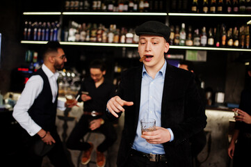 Stylish arab man against group of handsome retro well-dressed guys gangsters spend time at club, drinking on bar counter. Multiethnic male bachelor mafia party in restaurant.