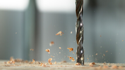 Detail of drill making hole into plywood