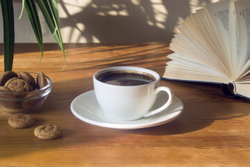 Still life with a Cup of coffee, cookies and a book. The atmosphere of a cozy morning Breakfast at home or in a cafe.